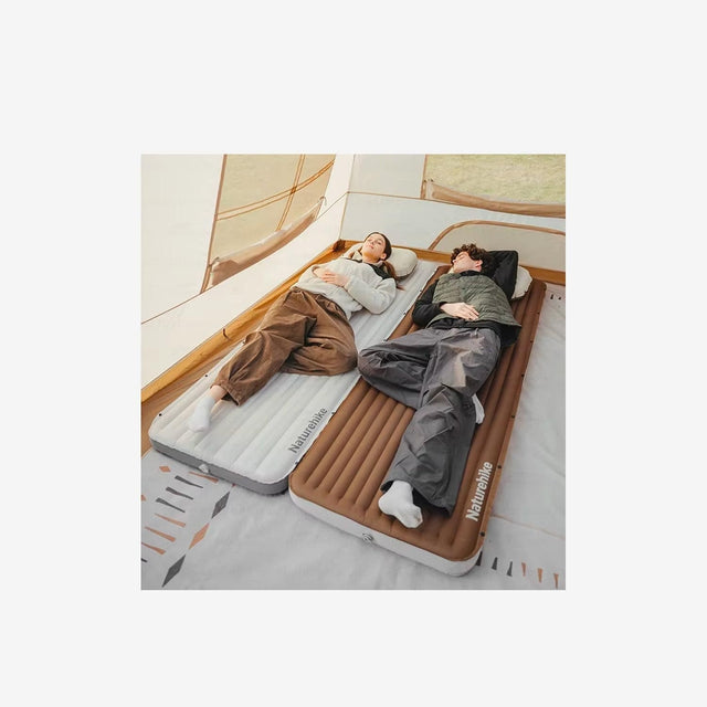 Two campers resting on connected Naturehike air mattresses inside a tent
