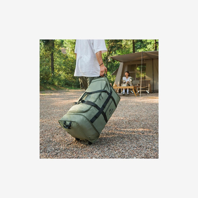 Traveler pulling Naturehike 88L collapsible tug bag through gravel