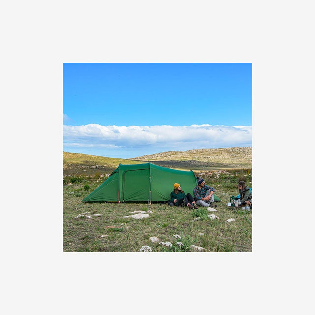 Campers setting up the Opalus 3P tent on a mountain or forest campsite
