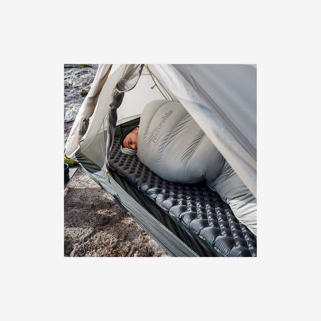 Couple relaxing on R3.5 double sleeping pad inside a tent