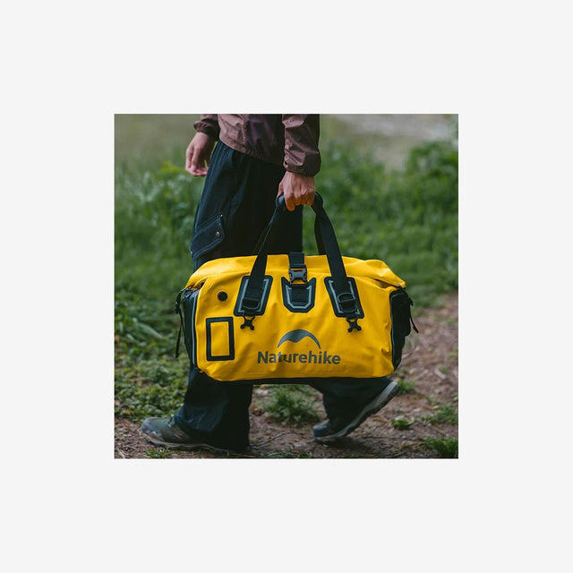 Camper carrying rugged duffel dry bag across rocky terrain