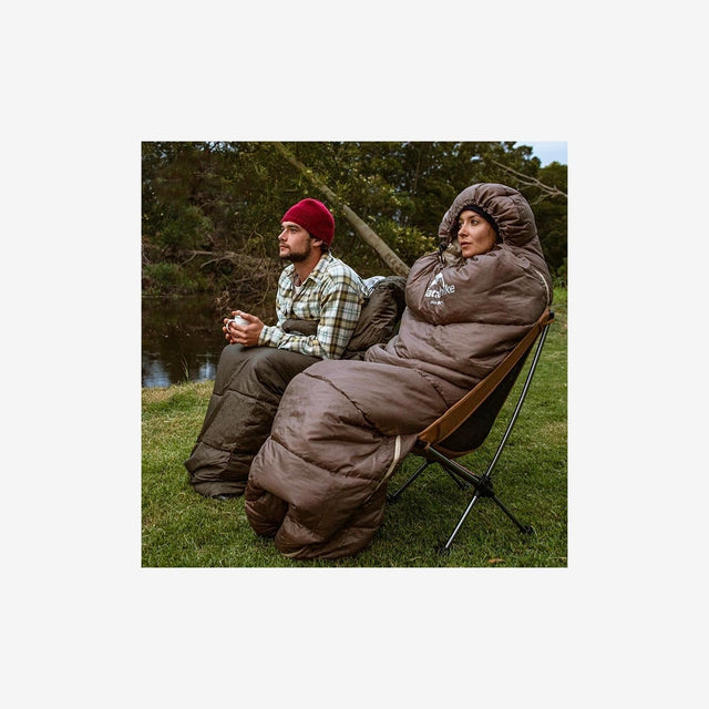 Camper resting comfortably inside Naturehike U Series sleeping bag outdoors